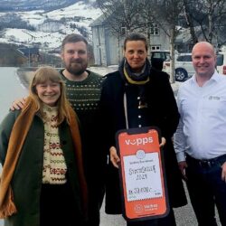 Gründerstipend til ny handlegate for lokale produsentar i Valdres frå Valdres Sparebank. Lykkelege günderar og banksjefen fra venstre: Simon Thunestvedt, Kristine Flatland Larsen, Bjørn Nylander og Erika Lystedt har gått saman om å søkje – og har fått tildelt – Valdres Sparebank sitt gründerstipend "Støttespiller" på 50 000 kroner. Midlane skal brukast til å realisere eit spennande prosjekt som set lokale produsentar i fokus og fremjar berekraftig utvikling i Valdres. Ei tillitsbasert handlegate for lokal handel I første fase planlegg dei fire gründerane å etablere ei "handlegate" for lokale produsentar, frå Lomen til Hemsing Bru. Denne unike handlegata skal bestå av ubemanna, tillitsbaserte boder der bønder, handverkarar, bakarar og andre produsentar kan selje sine eigenproduserte varer direkte til forbrukarane. Konseptet byggjer på tillit og enkel tilgang til kortreiste varer og gir produsentane moglegheit til å tilby produkta sine utan kostbare mellomledd. Utvikling av hubbar for produsentar i heile Valdres Etter at handlegata er etablert, ynskjer prosjektet å inkludere fleire produsentar frå heile regionen. Planen er å utvikle såkalla "hubbar" – samlingspunkt der lokale aktørar kan tilby varene sine under ei felles merkevare. Desse hubbane vil styrkje samarbeidet mellom produsentane og gi dei større marknadsmoglegheiter. Felles merkevare og marknadsføring Målet med prosjektet er å etablere ein ideell organisasjon som kan fungere som ein felles fasilitator for produsentar av lokalmat og handverk i Valdres. Gjennom ei sterk felles merkevare og målretta marknadsføring ynskjer dei å gjere kortreiste, rimelege lokalvarer meir tilgjengelege både for innbyggjarar og turistar. Styrkjer reiselivet og gjer Valdres meir attraktivt Prosjektet har potensial til å styrkje reiselivet i Valdres ved å tilby ei autentisk oppleving som fremjar lokal kultur og berekraft. Samstundes kan det bidra til å gjere dalføret meir attraktivt både for besøkjande og innbyggjarar ved å tilby rimelege og lett tilgjengelege produkt av høg kvalitet. "Dette prosjektet kan verkeleg gi produsentar i Valdres ein ny plattform for å nå ut til både lokale kundar og turistar," seier Kristine Flatland Larsen. "Vi er svært takksame for støtta frå Valdres Sparebank og ser fram til å ta fatt på arbeidet." Med gründerstipendet på 50 000 kroner har Thunestvedt, Larsen, Nylander og Lystedt fått ein god start på sitt visjonære prosjekt, som har store moglegheiter for å skape verdiar og vekst i regionen.